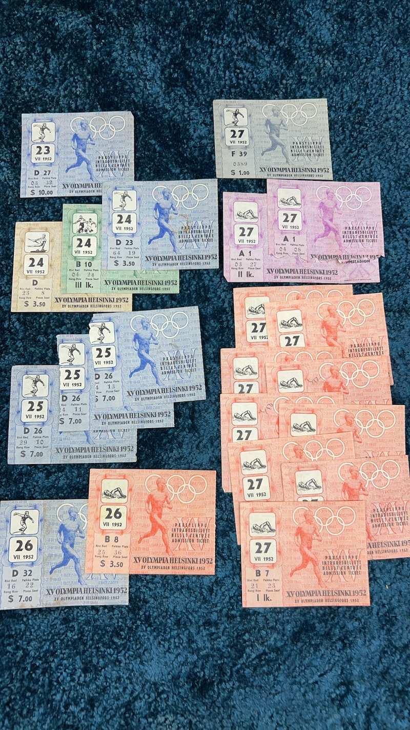 Rows of colorful 1952 Olympic Games tickets laid out on a blue cloth