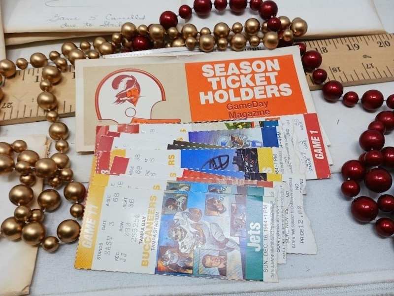 A fanned stack of Buccaneers game tickets with a Season Ticket Holders folder
