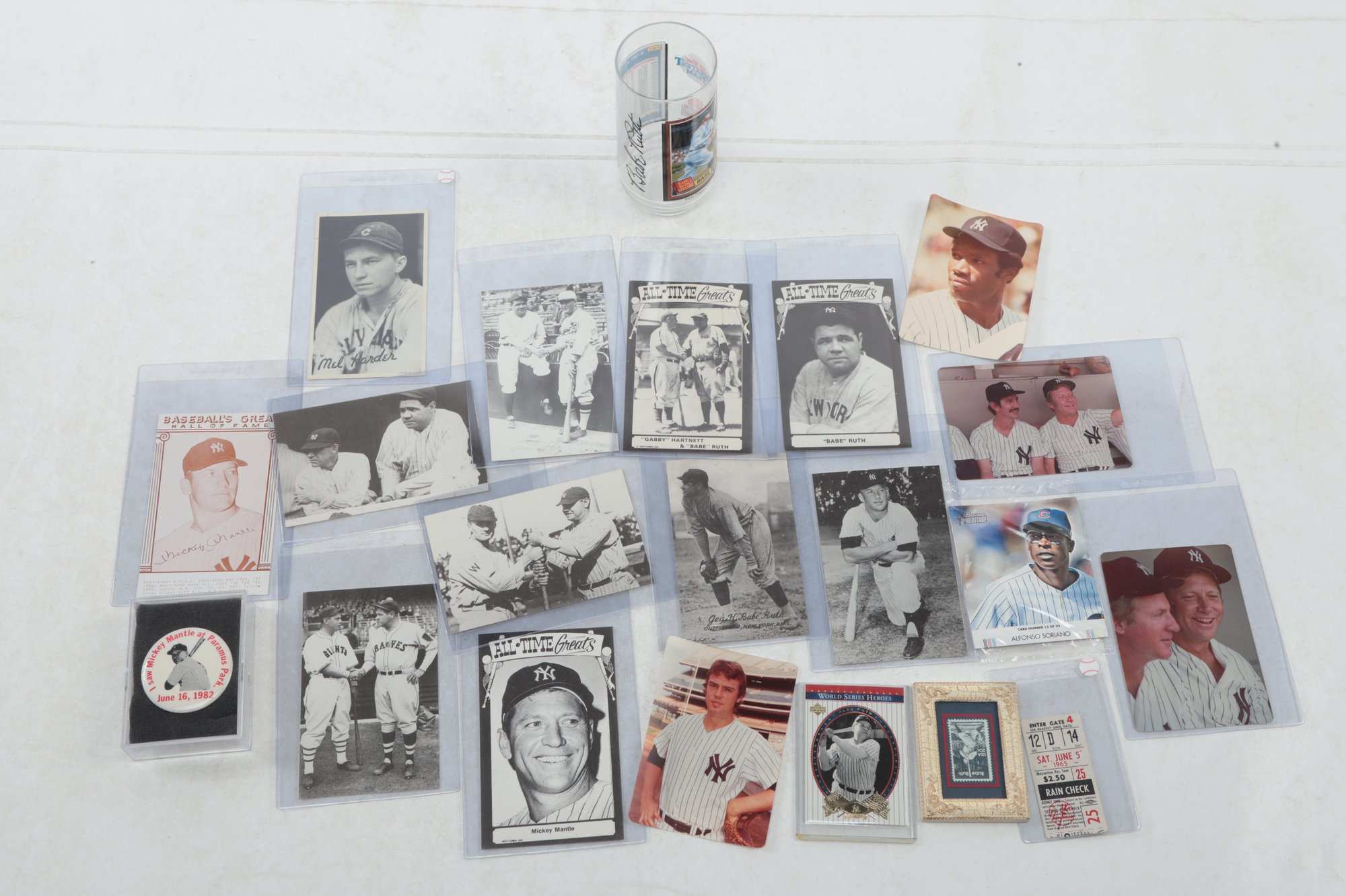 Vintage Babe Ruth, Mickey Mantle and Yankees cards and photos in sleeves, with a 1965 rain check and a Mantle pin