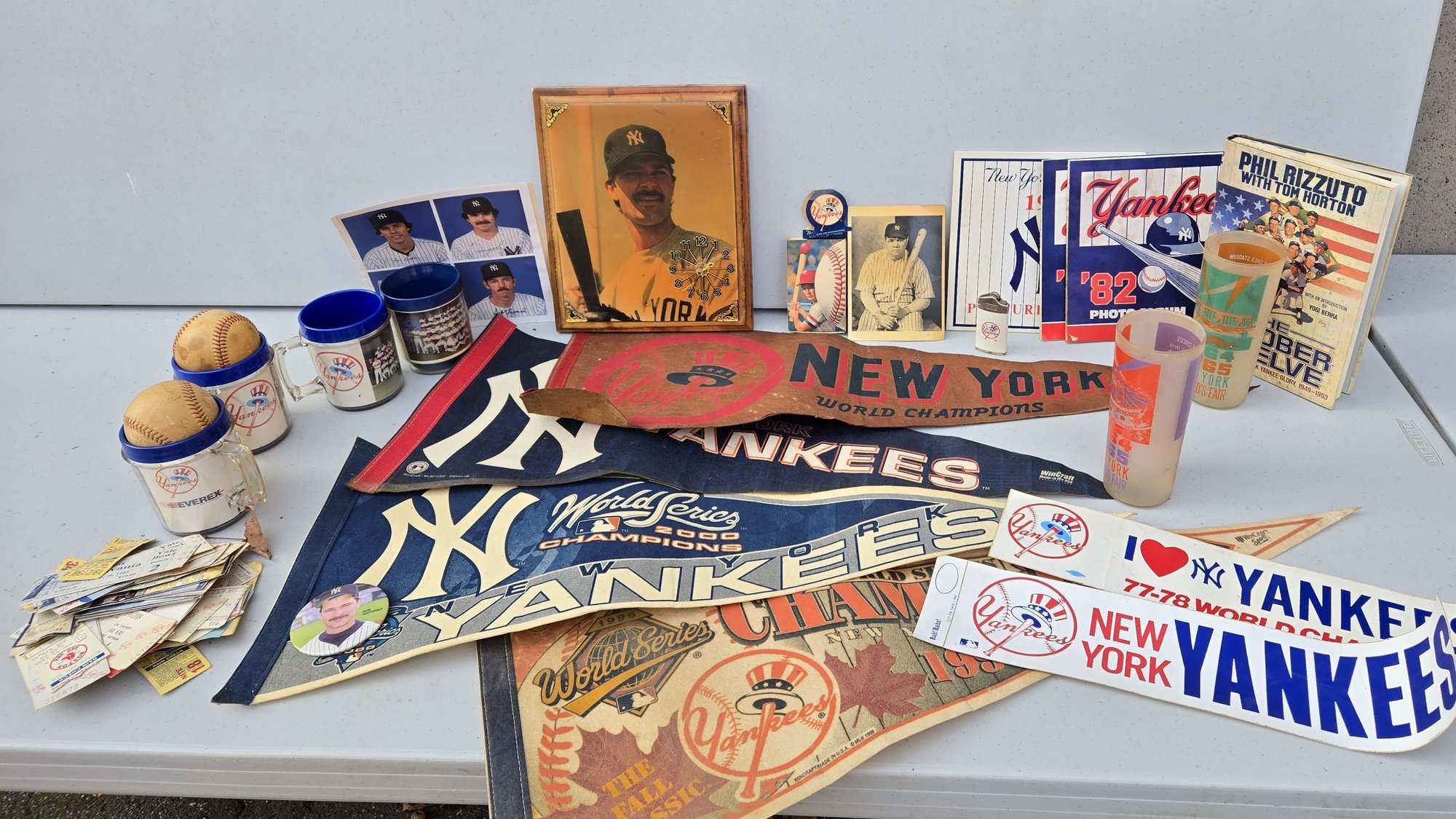 A Yankees memorabilia lot: pennants, yearbooks, a photo album, mugs, baseballs and ticket stubs